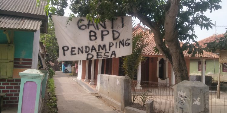 Warga Desa Sende Bentangkan Spanduk Bertuliskan Ganti BPD dan Pendamping Desa