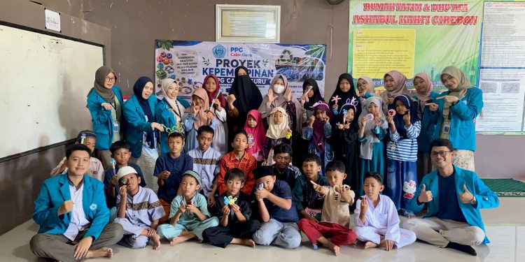 Caption Foto: Mahasiswa Kelompok 2 PPG Universitas Swadaya Gunung Jati (UGJ) berfoto bersama anak-anak dan pengurus Panti Asuhan Ashabul Kahfi, Cirebon, usai menggelar pelatihan kerajinan kawat bulu (pipe cleaner) dalam rangka Projek Kepemimpinan, Minggu (13/9/2026).